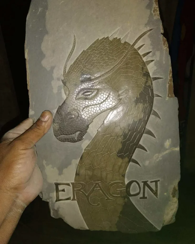 Stone Carvings of Dragon Neck and Head with Eragon Written Across the Bottom
