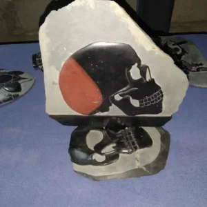 Stone Carvings Two Pieces Black Skulls, Top Skull with Profile View and Back of Skull is Orange and Front is Black